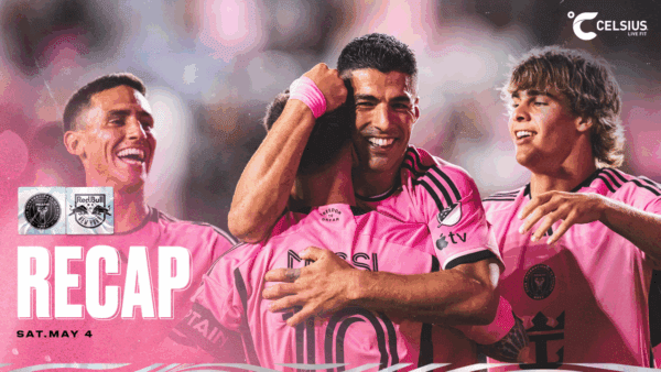 Soccer players celebrating in pink uniforms.