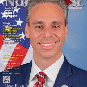 Man in suit with American flag background.