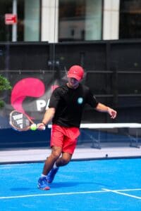 Man playing padel on blue court.