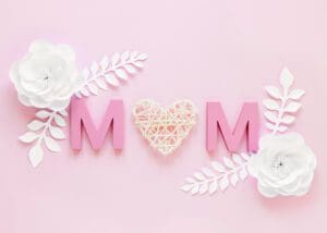 Pink 'MOM' with flowers on pink background.