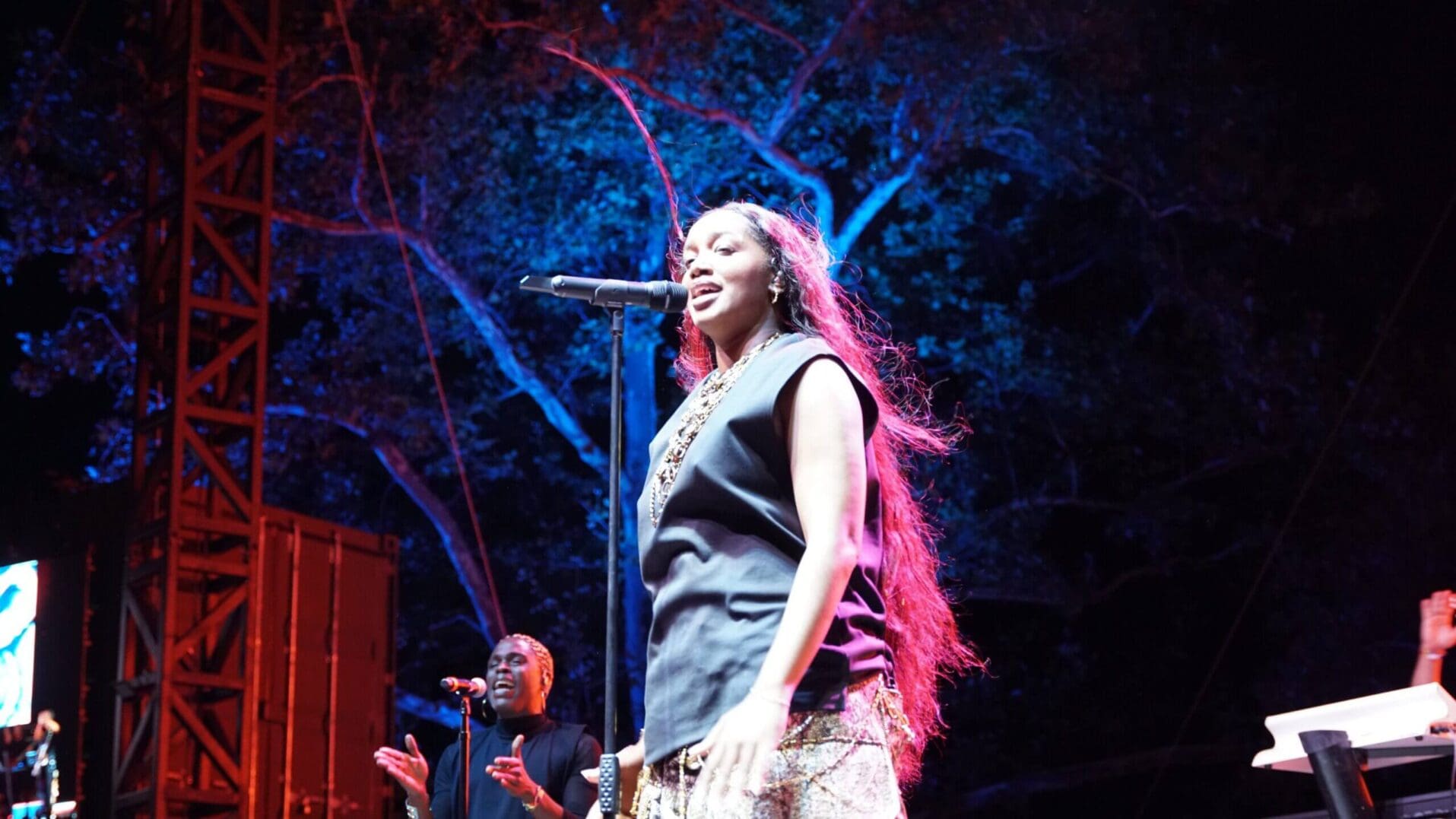 Singer performing on stage under colorful lights.