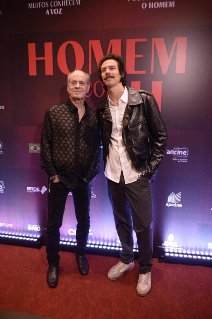 Two men posing at a red carpet event with a "Hotel M" backdrop.