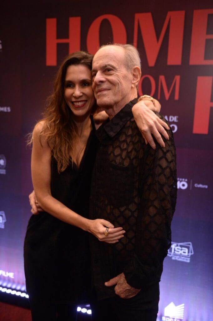 A couple embracing and smiling at a formal event.