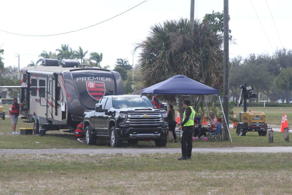 Security personnel managing an event with a black truck and a tent.