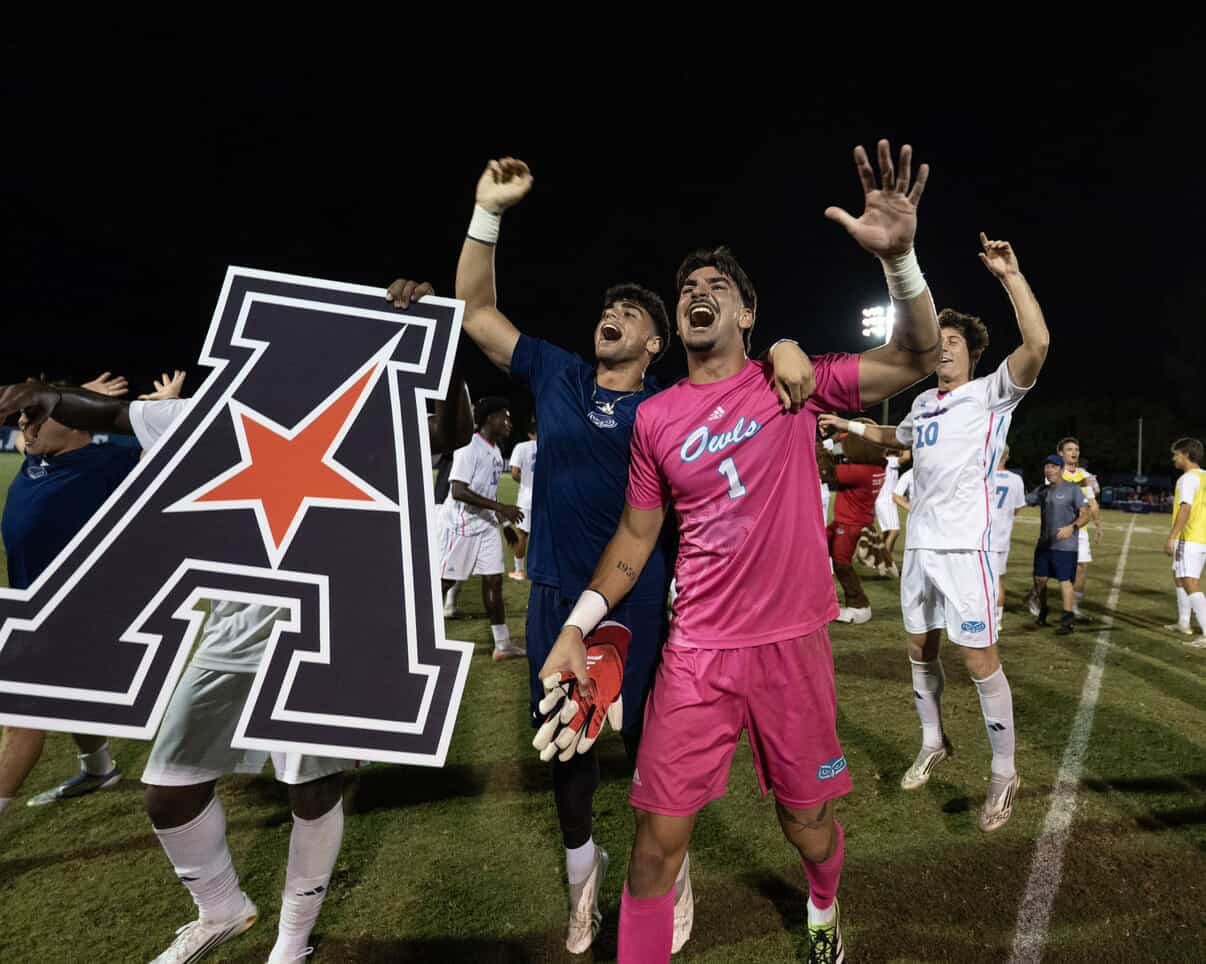 Soccer players celebrating victory on field.