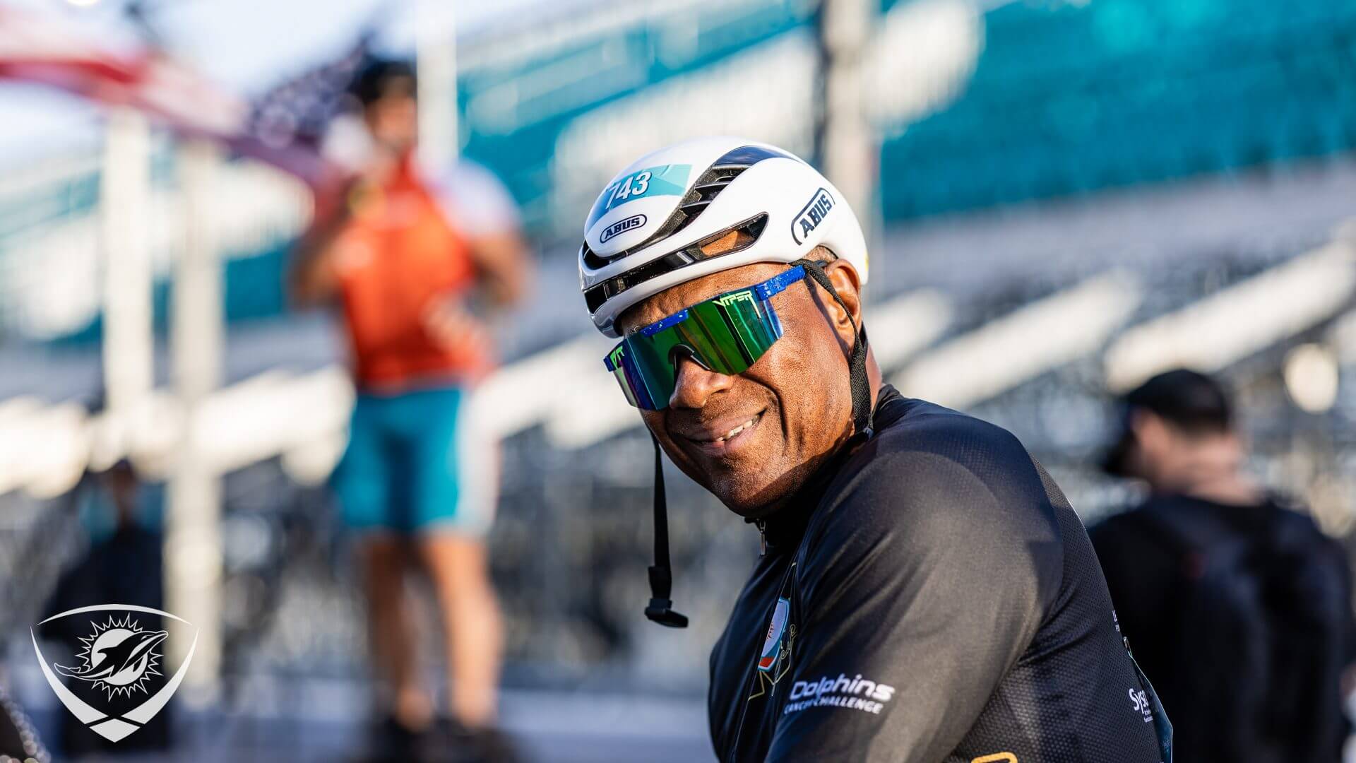 Cyclist smiling with helmet and sunglasses.