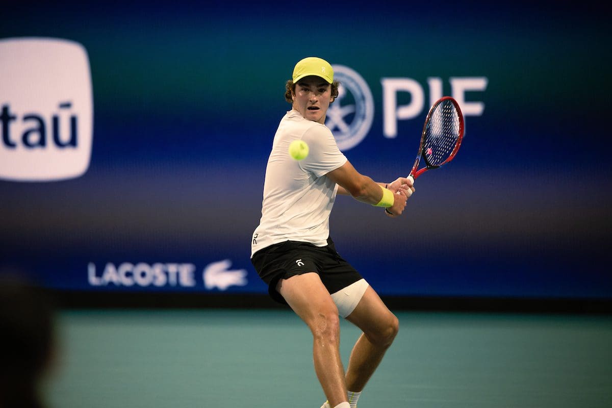 Tennis player hitting a backhand shot.