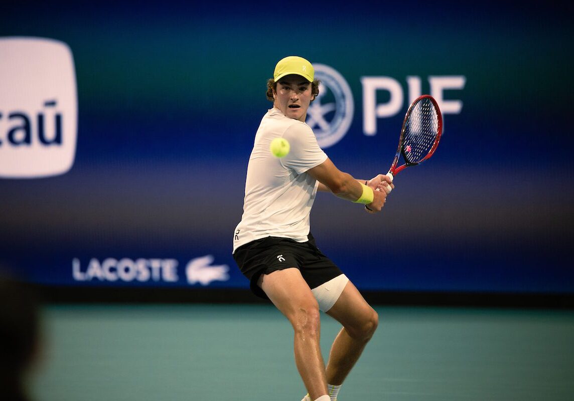 Tennis player hitting a backhand shot.
