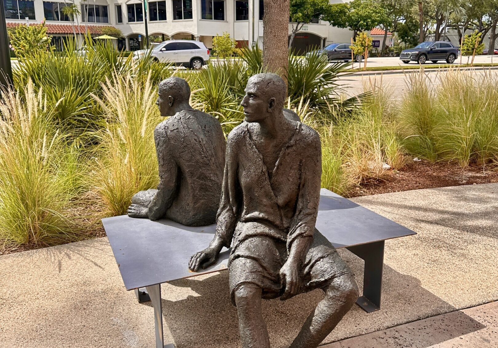 Bronze sculptures of seated figures on bench.