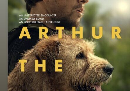 Man and dog on movie poster outdoors.