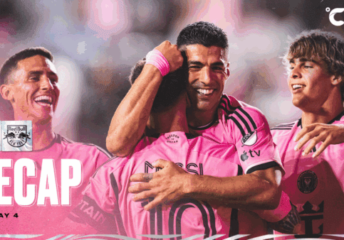 Soccer players celebrating in pink uniforms.